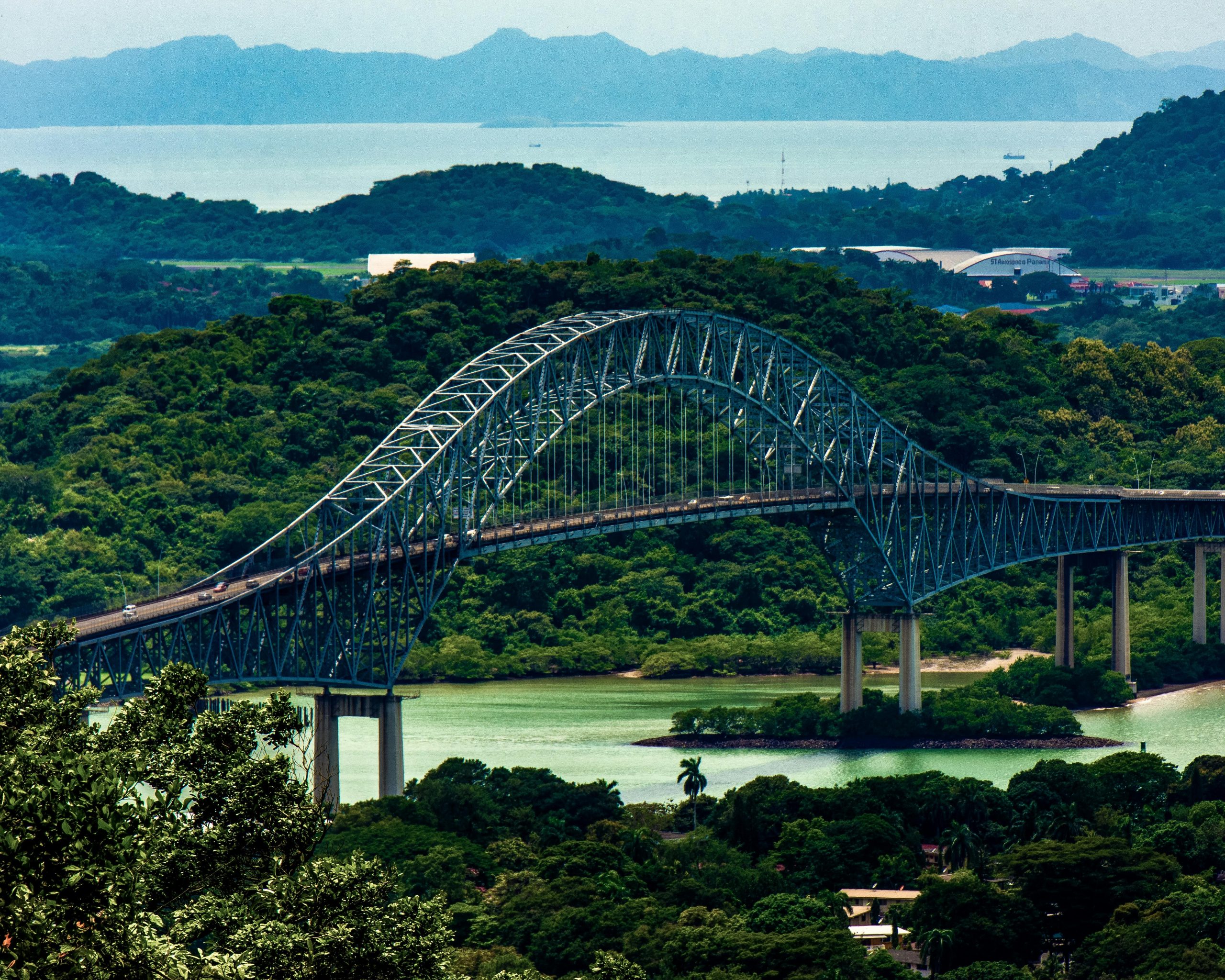A scenic view of the Puente de las Americas spanning over Panama's lush forests and water.