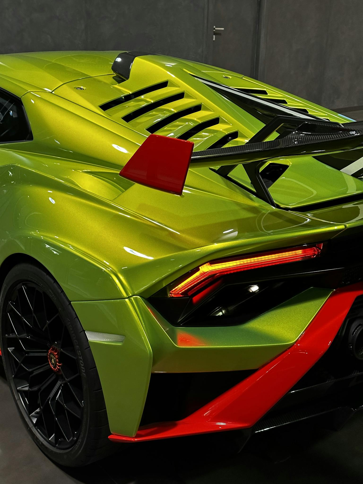 Close-up of a vibrant green and red Lamborghini Huracan STO showcasing its sleek design and sporty elegance.